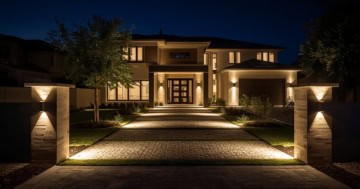 Beleuchtete Einfahrt eines modernen Hauses bei Nacht mit eleganten LED-Außenleuchten