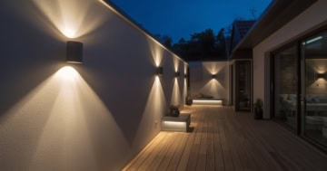 Stilvolle Wandleuchte Außen Terrasse an einer modernen Hausfassade bei Abenddämmerung